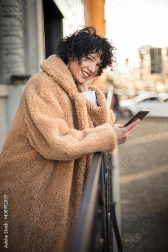 Woman on street holding smart phone. 