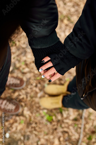 Modern young couple holding hands while standing in the woods outdoor travel concept