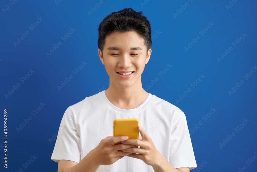 handsome young man sending text messages with is mobile phone, handsome young man sending text messages with is mobile phone,