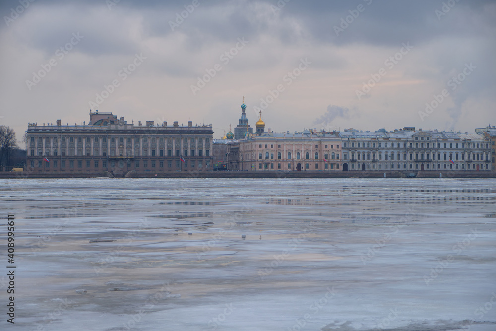 Obraz premium View of the frozen Neva River and the embankment in the historical center of St. Petersburg in Russia on a cloudy winter day