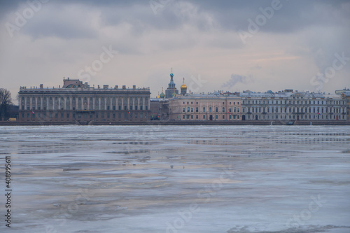 View of the frozen Neva River and the embankment in the historical center of St. Petersburg in Russia on a cloudy winter day