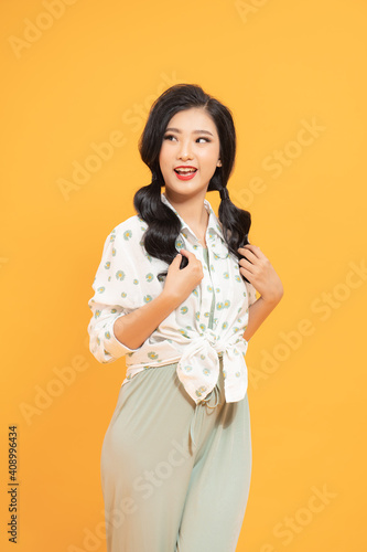 Close up portrait of young happy woman on yellow background © makistock