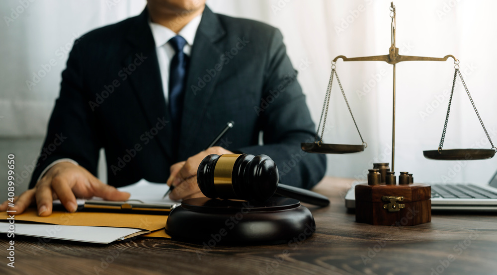 Business and lawyers discussing contract papers with brass scale on desk in office. Law, legal services, advice, justice and law concept picture with film grain effect Business and lawyers discussing contract papers with brass scale on desk in office. Law, legal services, advice, justice and law concept picture with film grain effect