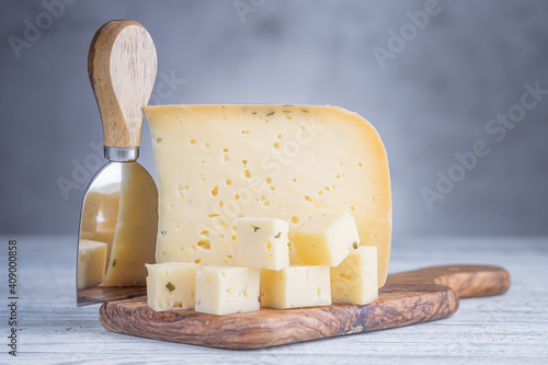 Piece of ammergauer beer cheese on a light wooden table photo