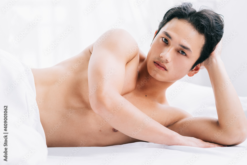 The muscular man is lying on the bed The muscular man is lying on the bed