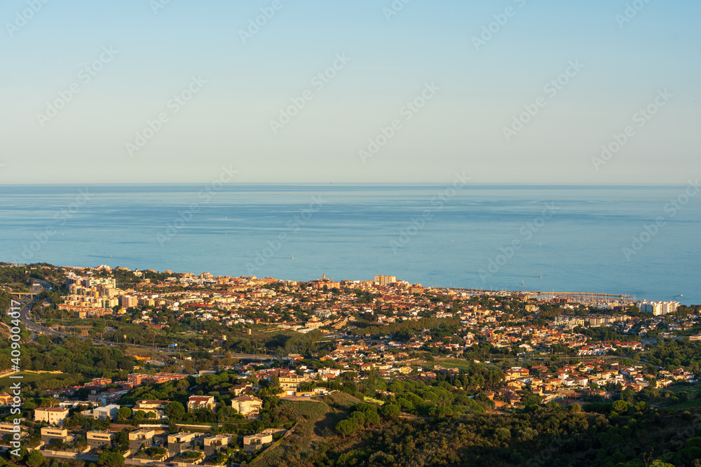 Panoramic view of the Maresme coast, north coast of the city of Barcelona. During sunset one day in late summer. We can see the Mediterranean sea completely flat.