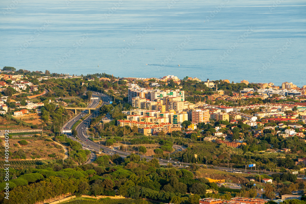 Panoramic view of the Maresme coast, north coast of the city of Barcelona. During sunset one day in late summer. We can see the Mediterranean sea completely flat.