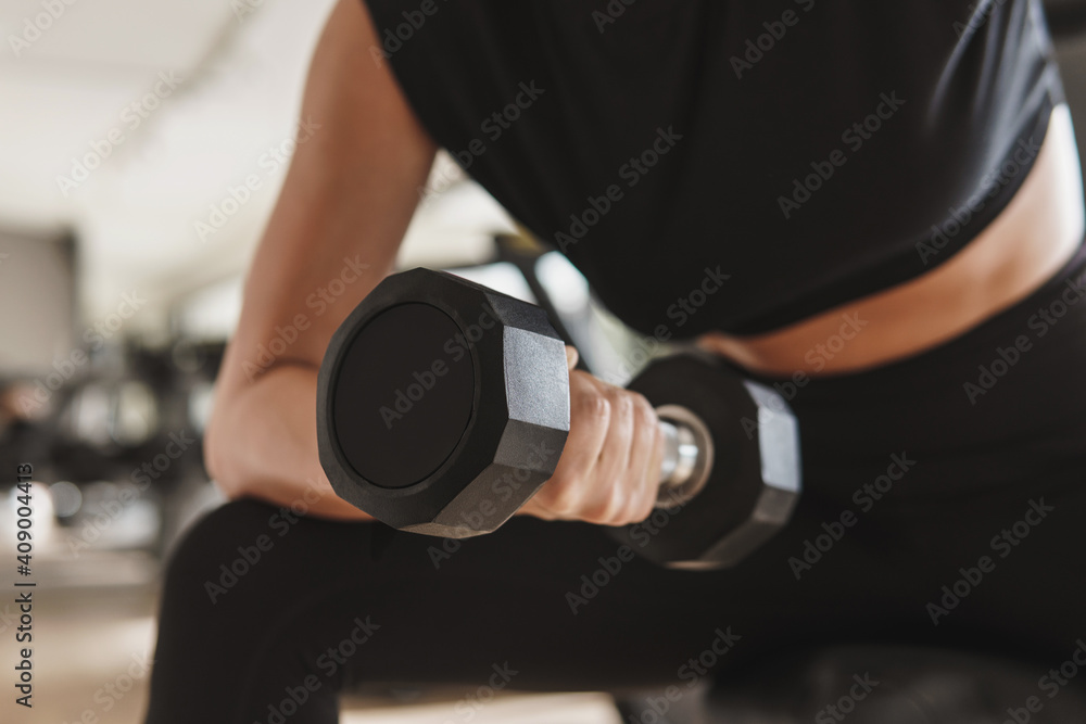 Female hand with a dumbbell during biceps curl exercise Female hand with a dumbbell during biceps curl exercise