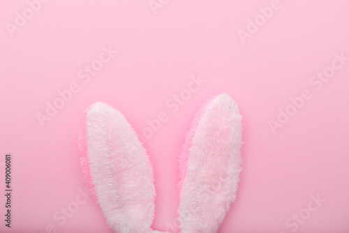 White rabbit ears on pink background, Easter minimal flat lay, top view, space for text