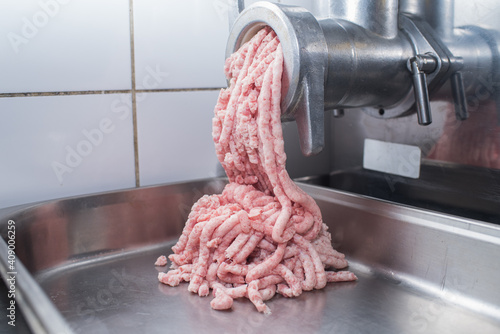 Fotografija In the kitchen, creating minced pork meat through a meat grinder