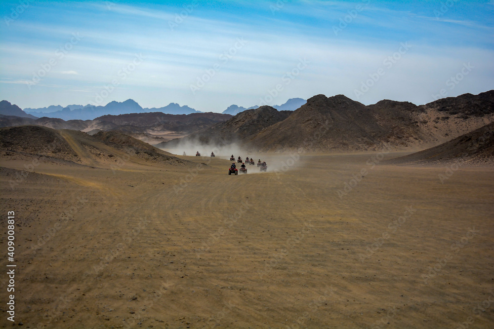tourists ride ATVs in the desert