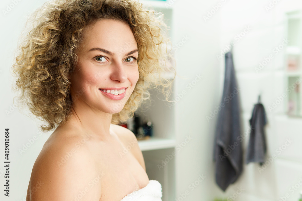 Beautiful woman with curly hair after a shower in a bathroom Beautiful woman with curly hair after a shower in a bathroom