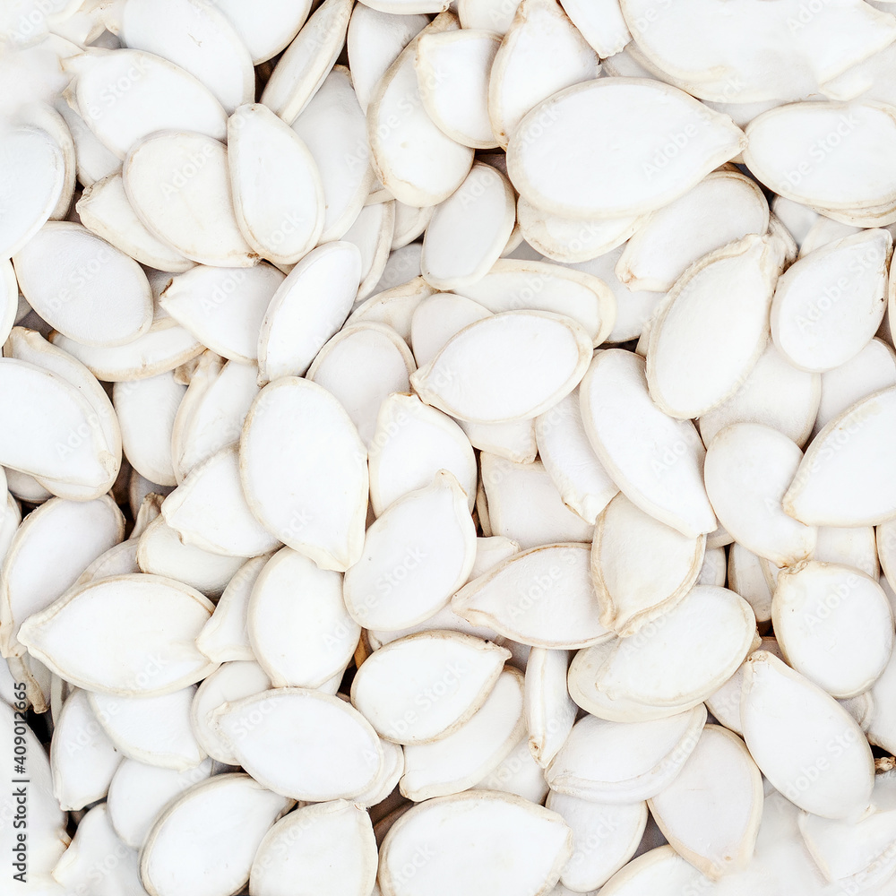 Pumpkin seeds as a background. Unpeeled white seeds close up. Top view. Texture. Pumpkin seeds as a background. Unpeeled white seeds close up. Top view. Texture.