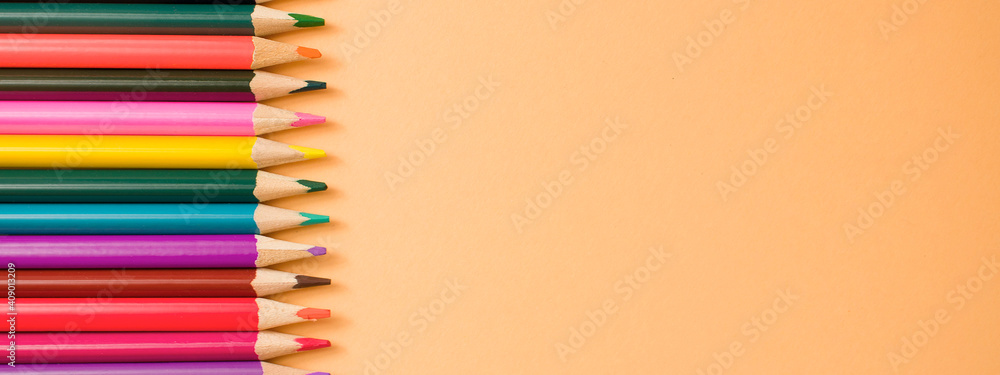 Photo banner. Close-Up Of colored pencil placed on yellow paper background with copy space for your image or text Photo banner. Close-Up Of colored pencil placed on yellow paper background with copy space for your image or text