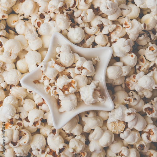 Some homemade Popcorn as detailed close-up shot, star shaped bowl, top view. Instagram matte filter.