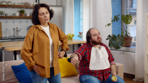 Senior mother and adult son hands in handcuffs at home photo