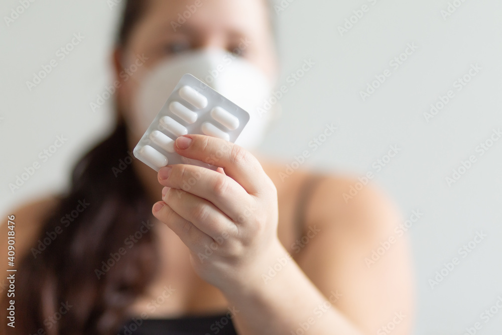 Girl in a mask on a white background holding a tablets Girl in a mask on a white background holding a tablets