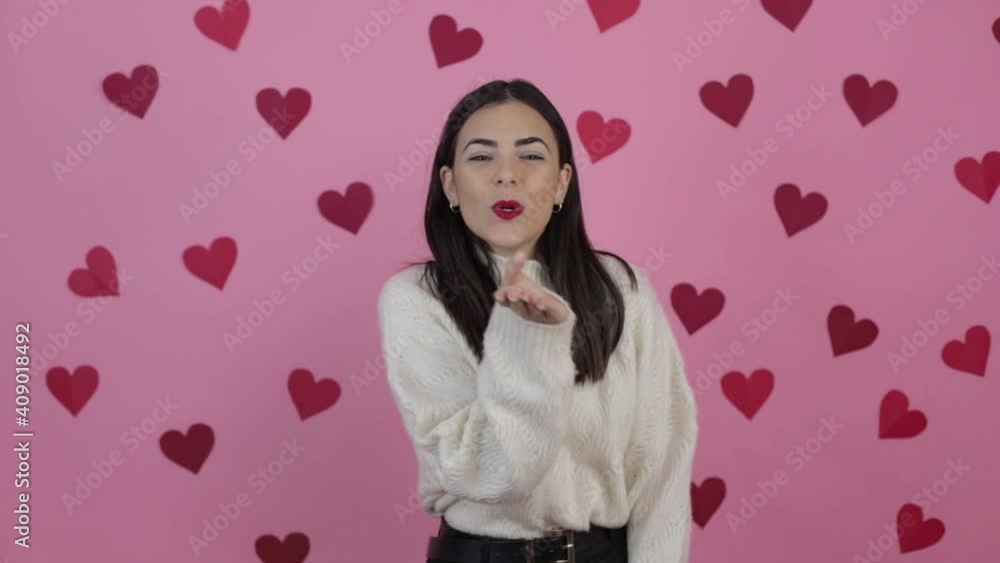 Pretty caucasian woman makes an air kiss to the camera during a photo shoot in the studio. Positive facial human emotion. Pretty caucasian woman makes an air kiss to the camera during a photo shoot in the studio. Positive facial human emotion.