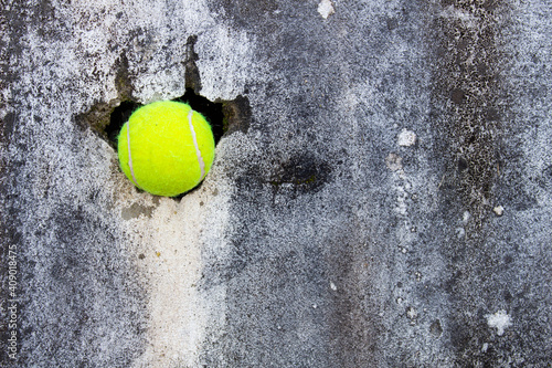 Tennis ball crashed the wall .Free space side for your text.