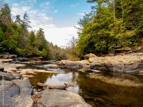 Swallow Falls State Park in Maryland in the fall with the creek bed and rocks in the foreground and the trees and sky in the background.  Beautiful nature in the mountains of Maryland.