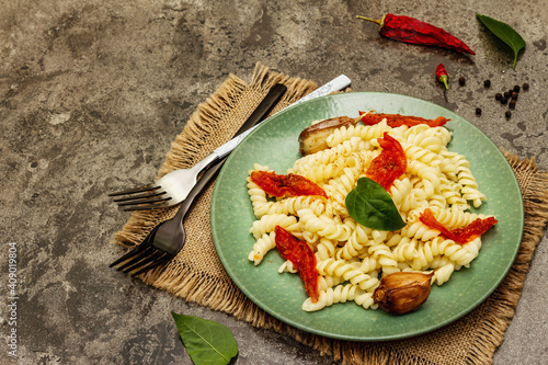 Gluten free fusilli pasta with baked garlic and tomatoes photo