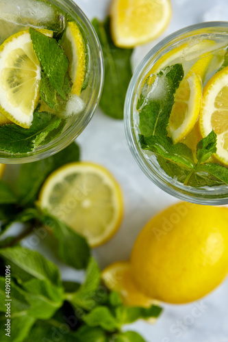 Refreshing drinks for summer, cold sweet and sour lemonade juice in the glasses with sliced fresh lemons. Refreshing summer drink. Traditional lemonade with lemon, mint and ice. Selective focus © Мария Чичина