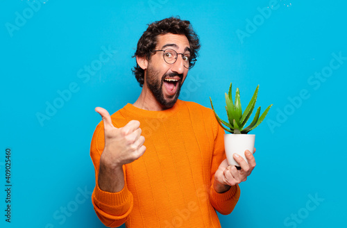 Photos young bearded man with a cactus plant