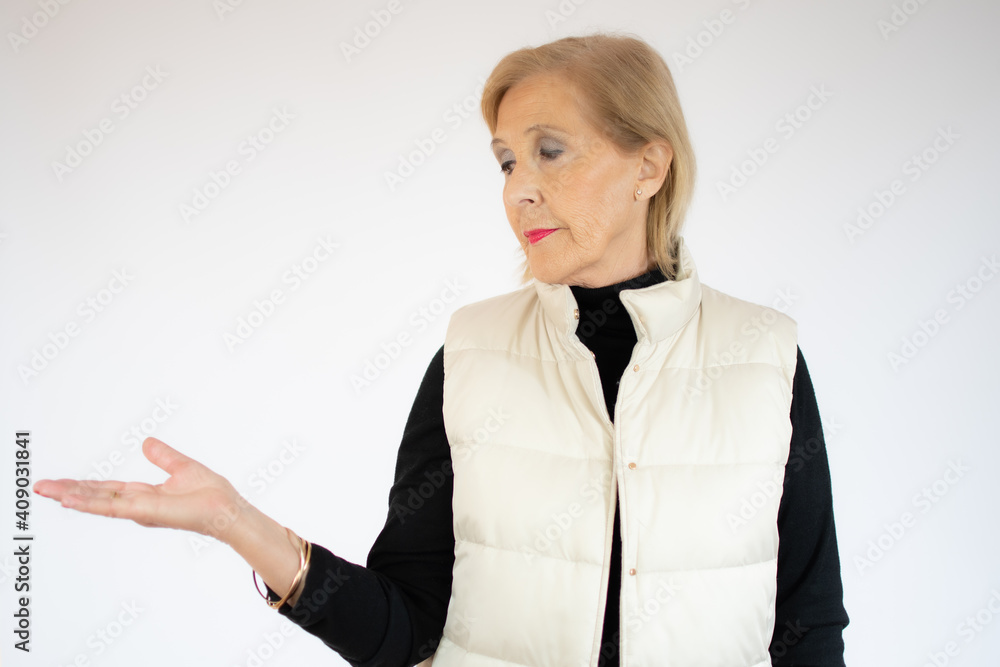 Senior woman presenting and pointing with palm over white background Senior woman presenting and pointing with palm over white background