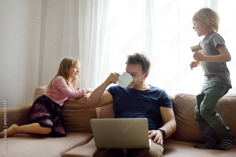 Tired father with his two kids during quarantine. Home office concept. Online working and household at the same time while lockdown