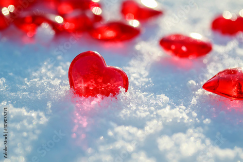 festive background with transparent red love symbols hearts lying on the snow