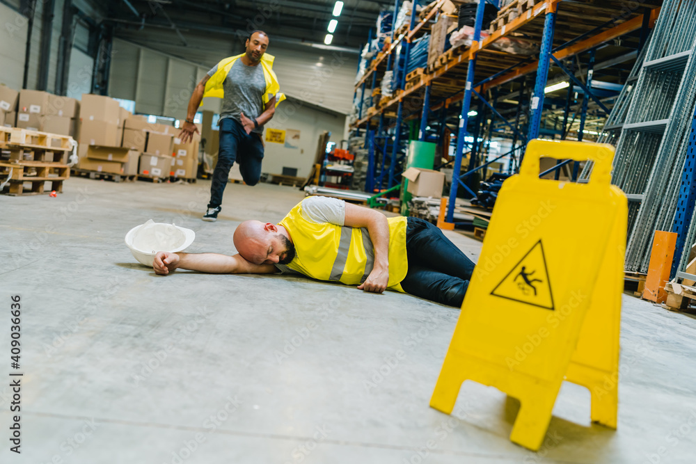 Injured storehouse worker being rescued bu his colleague Injured storehouse worker being rescued bu his colleague