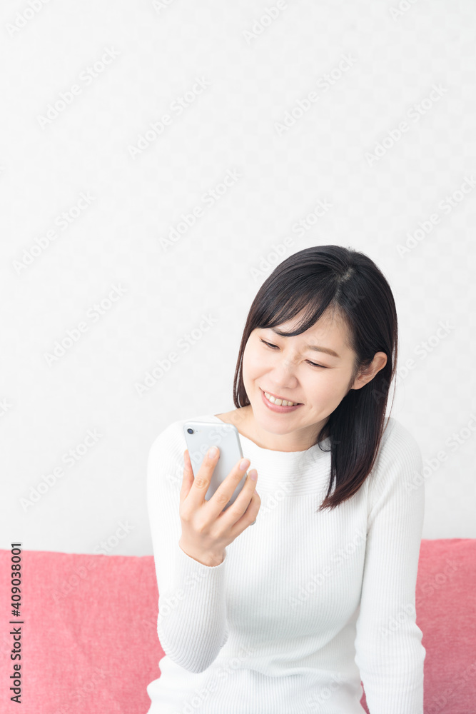 Woman sitting on the couch and holding a smartphone Woman sitting on the couch and holding a smartphone