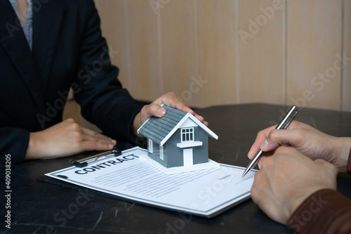 The house plan with the real estate agent and the client is signing a purchase agreement. And discussing home purchase contracts, real estate loans, lease and home purchase contracts