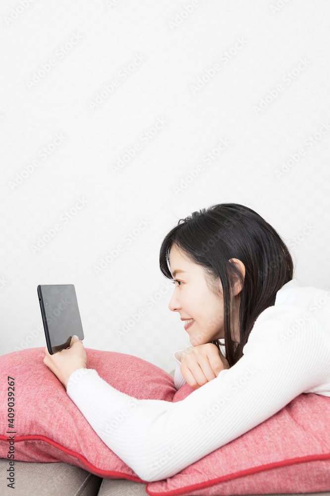 Woman lying on the couch and holding a tablet Woman lying on the couch and holding a tablet