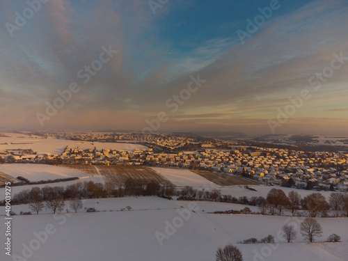 Aerial drone view of Lappersdorf and surrounding fields near Regensburg in Bavaria with snow during sunrise on clear cold winter day