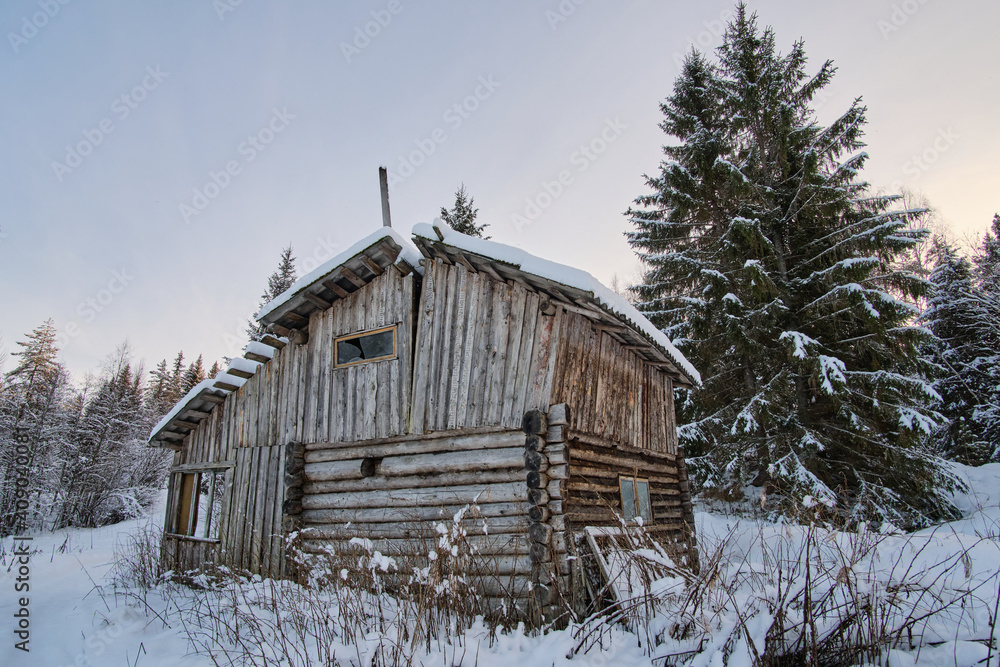An abandoned hut in a winter Karelian forest. Taiga dwelling at Russian north. An abandoned hut in a winter Karelian forest. Taiga dwelling at Russian north.