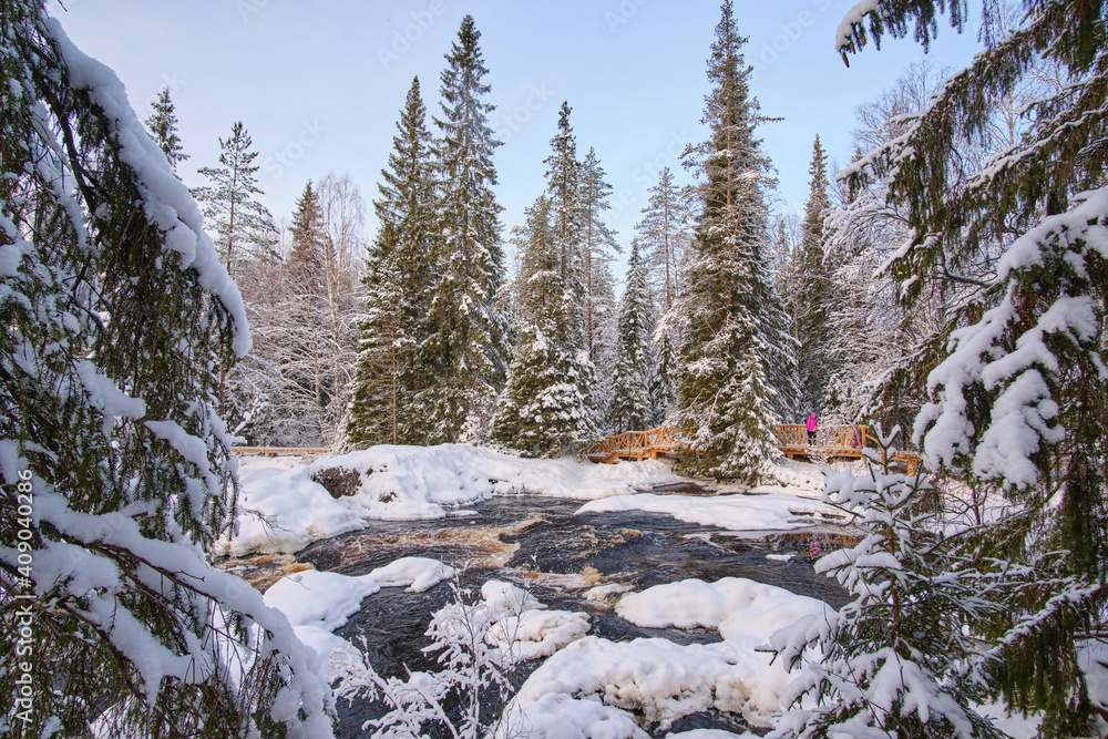 Rapids on a mountain river Tokhmajoki near Ahvenkoski waterfall at sunny winter weather. Ruskeala, Karelia.