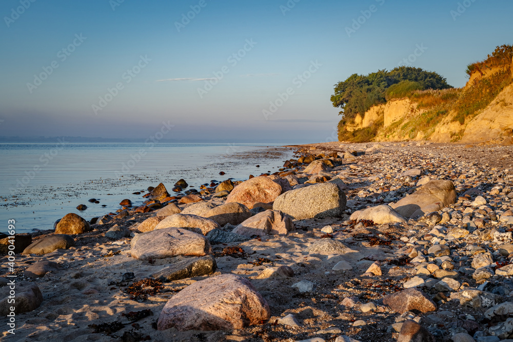Steiniger Strand vor der Steilküste bei Klein-Waabs bei Eckernförde in Schleswig-Holstein im Morgenlicht. Steiniger Strand vor der Steilküste bei Klein-Waabs bei Eckernförde in Schleswig-Holstein im Morgenlicht.