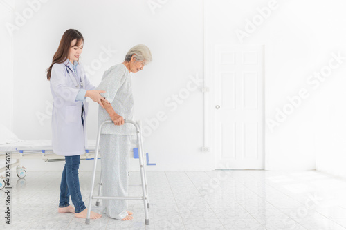 close up patient, walk training and rehabilitation process, old asian stroke patient learning to uses walker with female asian doctor in hospital, elderly healthcare promotion