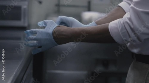 Manos de un trabajador poniendose guantes de latex photo