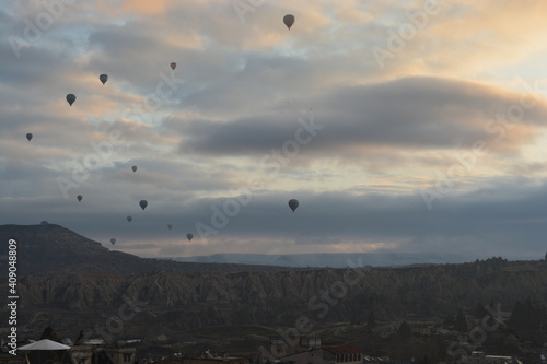 Tourist hot air balloons floating in the cloudy sky in Cappadocia. Cloudy weather. Colorful balloons.