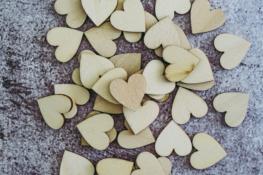 Obraz premium Coeurs en bois sur un arrière plan gris béton griffé - Arrière plan amour saint-valentin