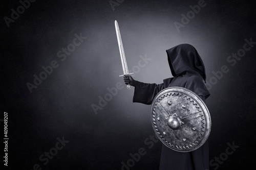 Ghostly figure with sword and round shield in the dark photo