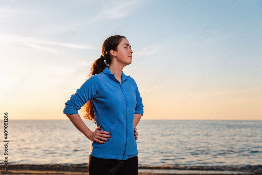 Young woman in sportswear posing on the background of the sea and sunset. Copy space. Wellness and sports lifestyle Young woman in sportswear posing on the background of the sea and sunset. Copy space. Wellness and sports lifestyle