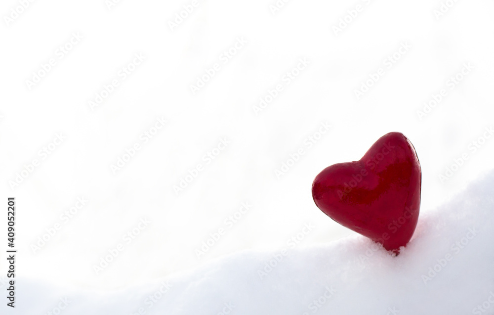 Beautiful red heart in the snow on a light background. Valentines day concept
