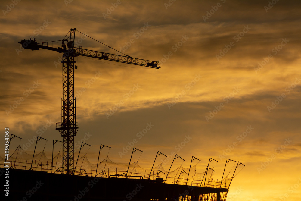 Silhouette of a crane and a building
