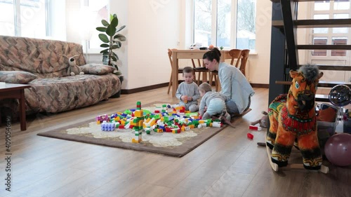 Mother and children playing with toy brick construction at home