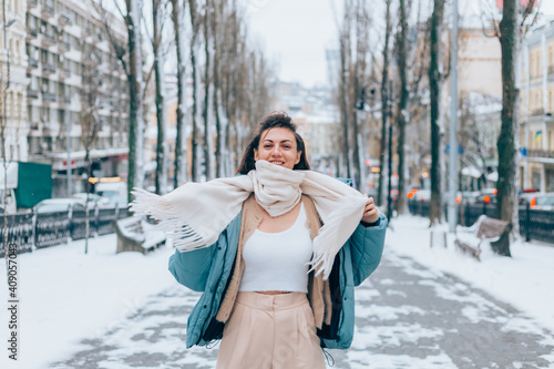 Happy woman in winter on snowy city alley