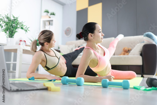 Women doing sports exercises on floor at home