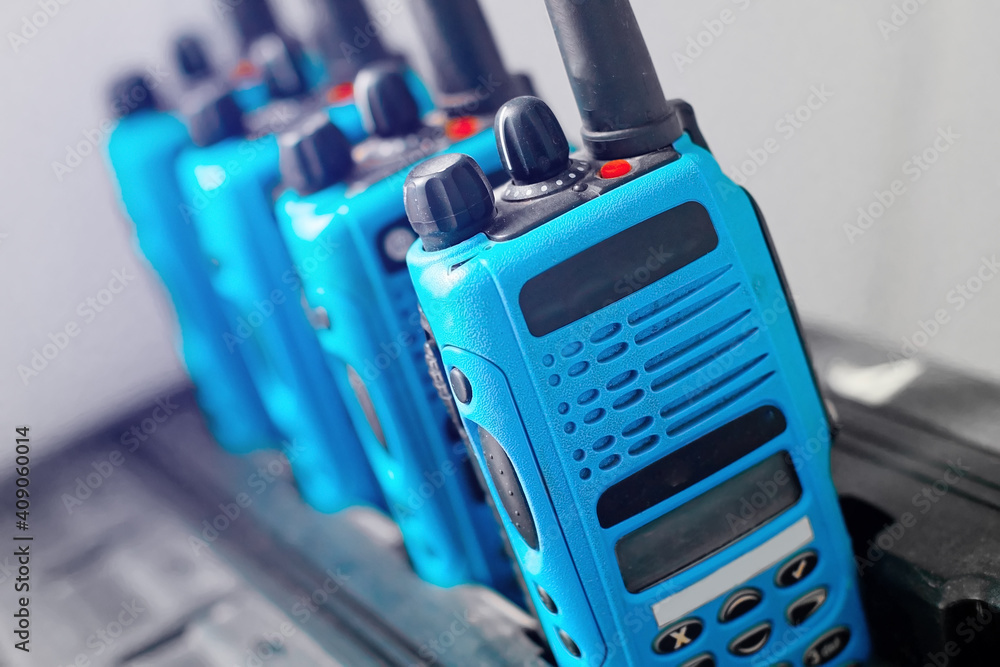 A set of blue walkie-talkies stand in a row. The concept of readiness for a rescue operation or the transmission of a stable radio communication over a distance. Copy space A set of blue walkie-talkies stand in a row. The concept of readiness for a rescue operation or the transmission of a stable radio communication over a distance. Copy space
